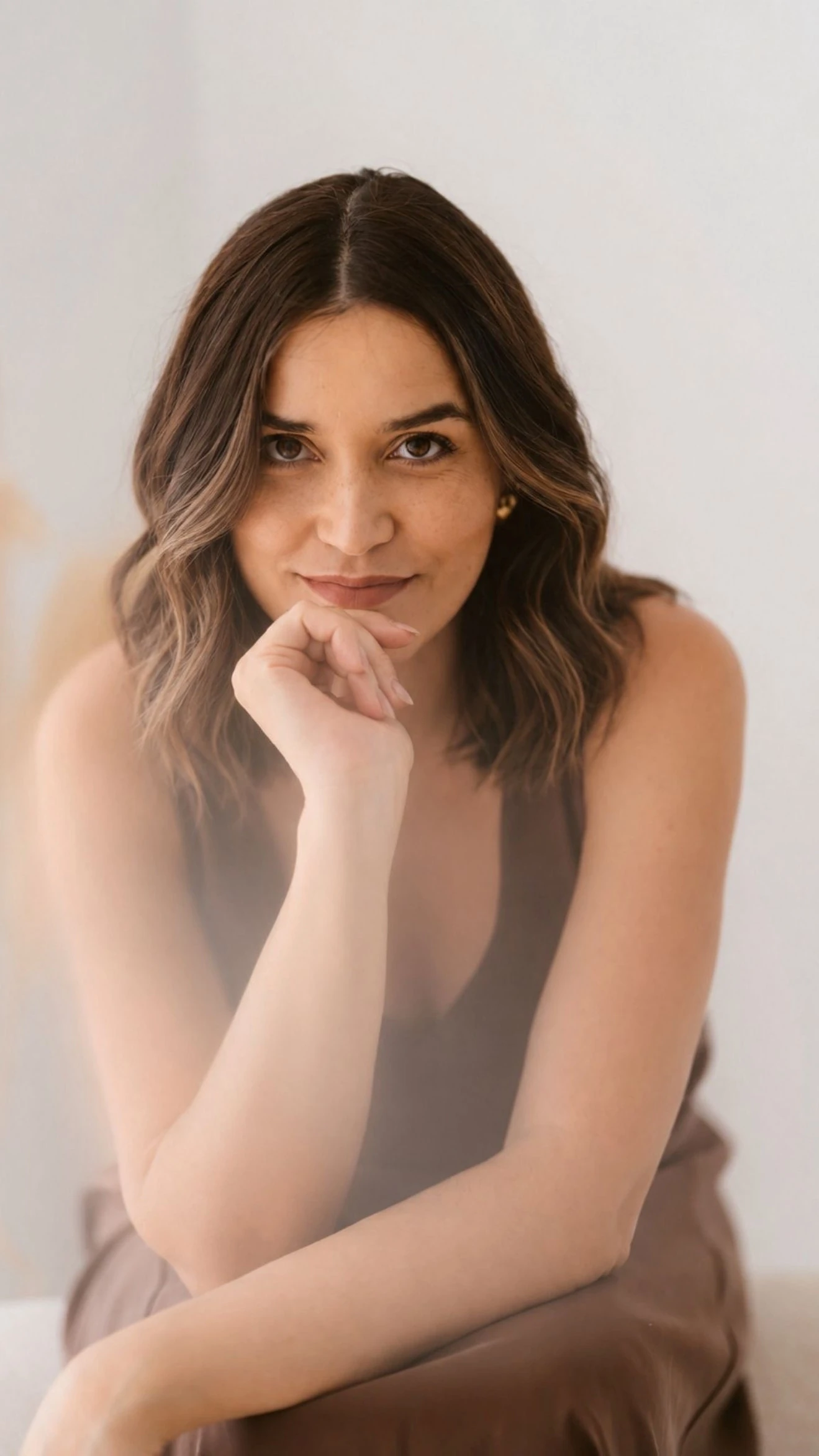 Retrato de Ana Cunha, sentada, com a mão no queixo e o olhar dirigido à câmara.
